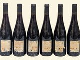 six bottles of red wine are lined up in a row