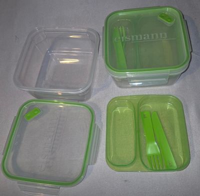 four plastic containers with spoons and forks on a table