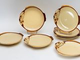 quatre assiettes et bols marron et blancs posés sur un plan de travail blanc