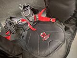 a black bag with a red handle and a pair of shoes in it