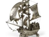 une maquette en argent représentant un voilier sur fond blanc