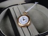 a gold pocket watch sitting in a case on a table