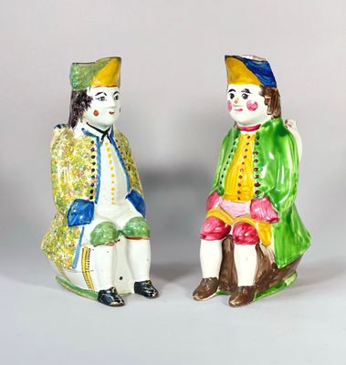 paire de figurines en céramique représentant des clowns assis sur une souche d'arbre