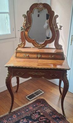 une coiffeuse en bois avec un miroir et un tapis au sol