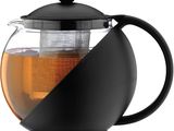 une théière noire contenant un verre et du thé