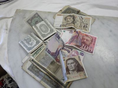a pile of money sitting on a table next to a laptop