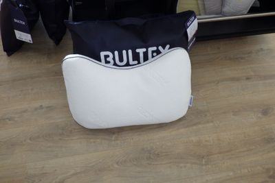un sac noir et blanc posé par terre à côté d'un miroir