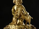 an antique gold statue of a woman with a goat on a marble base