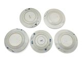 four plates with blue and white designs on them on a white surface