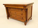 a small wooden chest of drawers on a white background