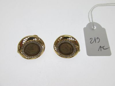 une paire de boucles d'oreilles dorées ornées de pierres marron et de diamants