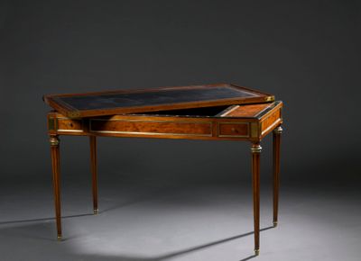 un bureau ancien avec un plateau en cuir et des pieds en laiton