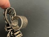 a person holding a silver ring with a bird on it