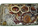 a box of assorted jewelry on a white surface