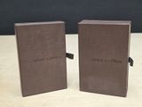 deux livres Louis Vuitton posés sur une table en bois