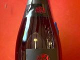 une bouteille de vin posée sur une table rouge