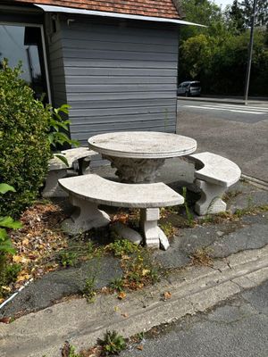 a stone table and bench on the side of the road