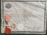 an old document with a medal and a red wax seal