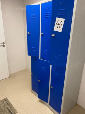 two blue lockers in a bathroom with a sign on the door