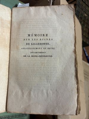 un livre ouvert posé sur une pile de livres