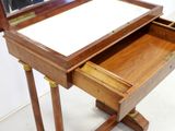 a small wooden desk with a mirror on top of it