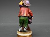 an image of a figurine of a man in a hat and green pants