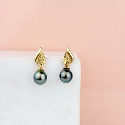 a pair of black pearl earrings with gold leaves on them