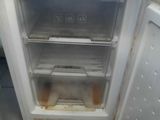 an open refrigerator with the door open on a tiled floor
