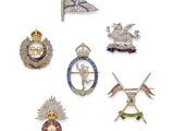 six different types of brooches and badges on a white surface