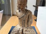 a wooden statue of a person sitting on a blue mat