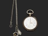 une montre de poche en argent et une clé attachée à une chaîne