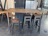 a table with four stools and a refrigerator in the background