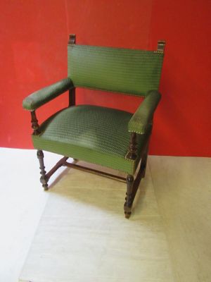 a green chair that is sitting in front of a red wall