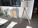 une lampe posée sur un trépied à côté d'une armoire