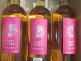 trois bouteilles de vin rosé sont posées dans une boîte sur une étagère
