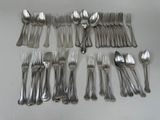 a lot of spoons and forks laid out on the table
