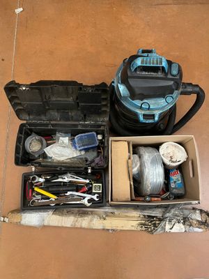 a box of tools sitting on the floor next to a vacuum