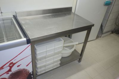 une table de travail en acier inoxydable équipée d'un évier et d'un congélateur