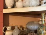 de nombreux vases différents sur les étagères de cette pièce