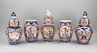 Plusieurs vases aux motifs variés sont alignés sur un fond gris.