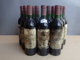 several bottles of wine are lined up on a wooden table