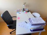 a desk with a chair and a lot of papers on it