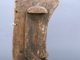 an old wooden mask hanging from the side of a wooden pole