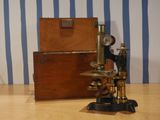 a microscope sitting on a table with a box in the background