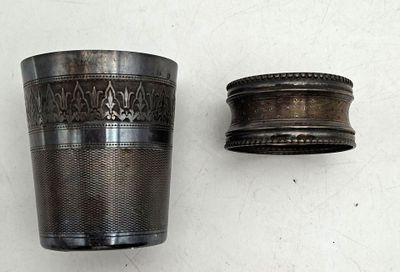 a silver cup sitting next to a silver cup on a table