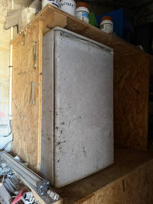 a white refrigerator sitting in the corner of a room