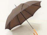 un parapluie marron avec un manche en bois sur un fond blanc