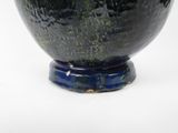a black and blue bowl sitting on a white surface