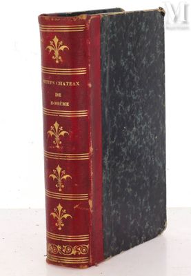 an old book sitting on top of a table next to a white wall