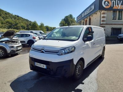 the white van is parked in front of a building in a parking lot